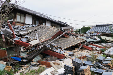 台風により屋根が飛ばされた後、敷地に散らばった屋根板を撤去している様子